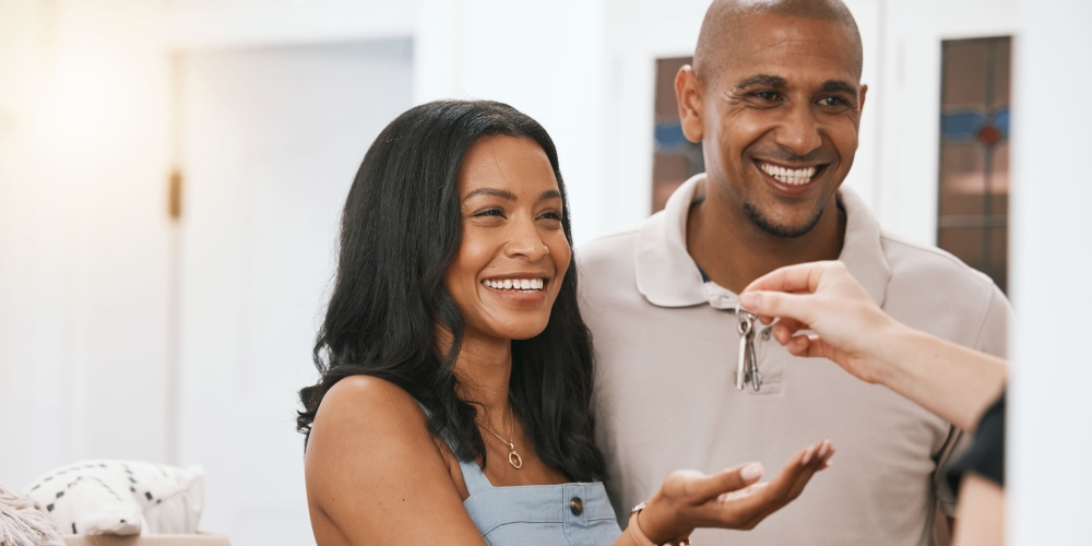 A happy couple receiving the keys to their new home. 