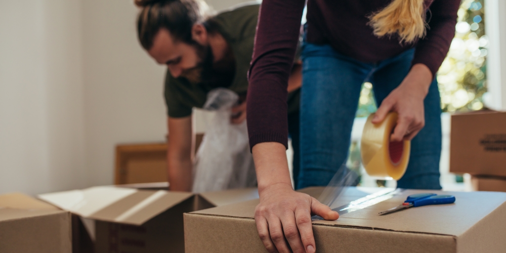 A man and a woman are packing boxes for their move