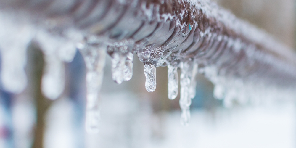 A frozen water pipe with icicles forming
