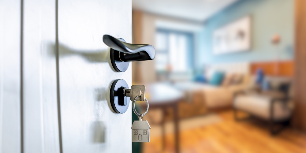An open door to an apartment with keys in the keyhole. 
