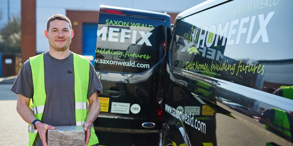 A repair man smiling by a HomeFix van