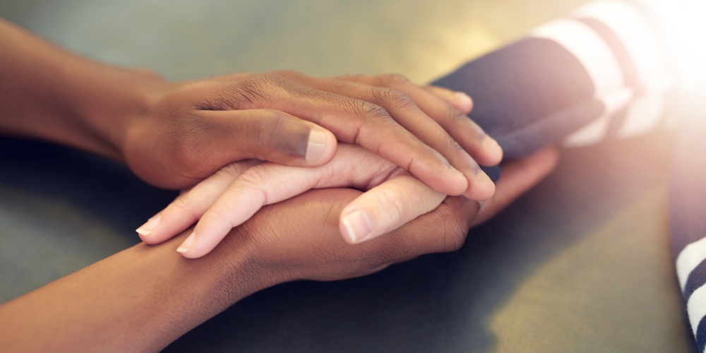 Friends holding hands across the table