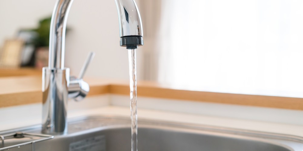 Water is flowing from a faucet into a kitchen sink