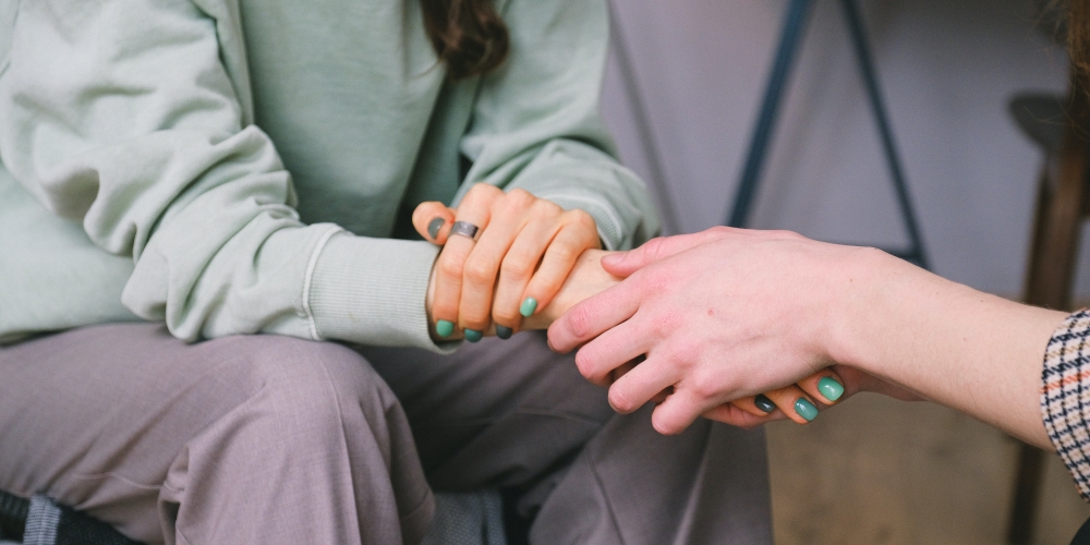 Two friends sat down, holding hands